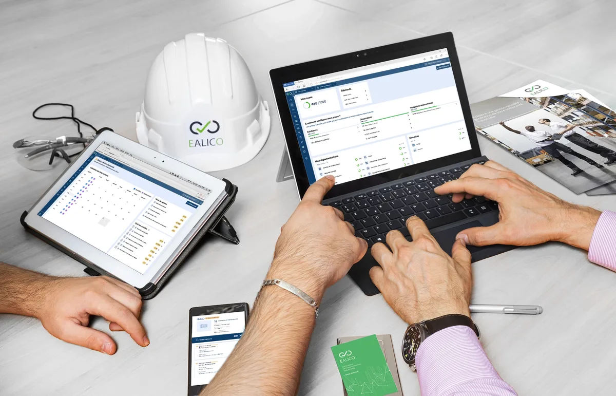 Paramétrage d'un compte Ealico : ordinateur portable et tablette ouverts sur l'application, casque de chantier Ealico posé à côté