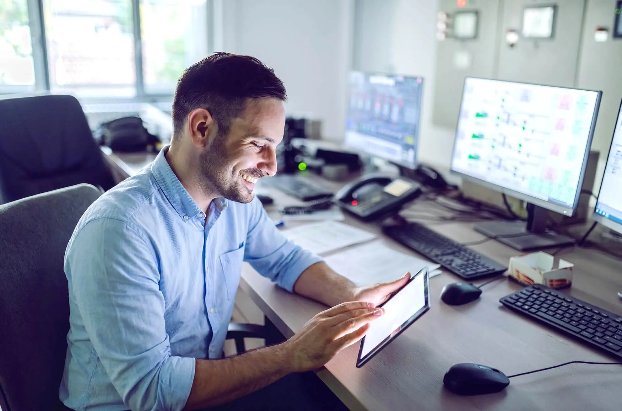 Responsable conformité consultant Ealico sur une tablette dans une salle de contrôle