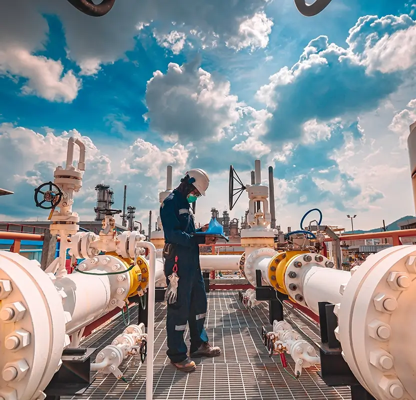 Opérateur inspectant des vannes sur une installation pétrochimique