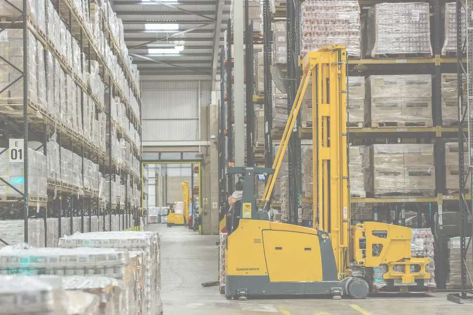 Chariot élévateur en manœuvre dans les allées d'un entrepôt de stockage