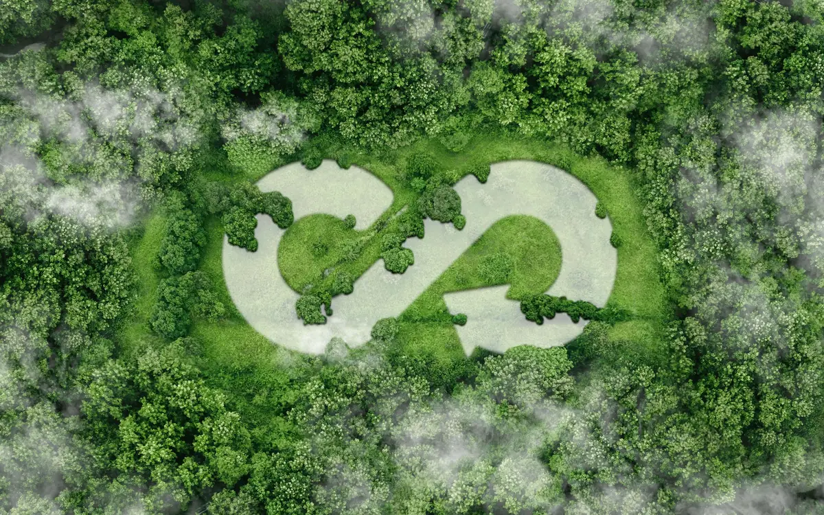 Vue aérienne d'une clairière dessinant le symbole du recyclage au cœur d'une forêt