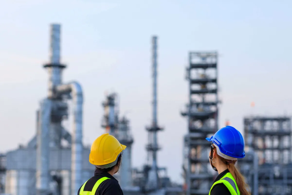 Deux techniciens casqués observent les installations d'un site industriel